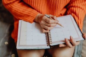 woman writing in a planner representing time mapping