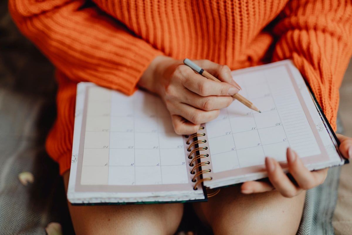 woman writing in a planner representing time mapping